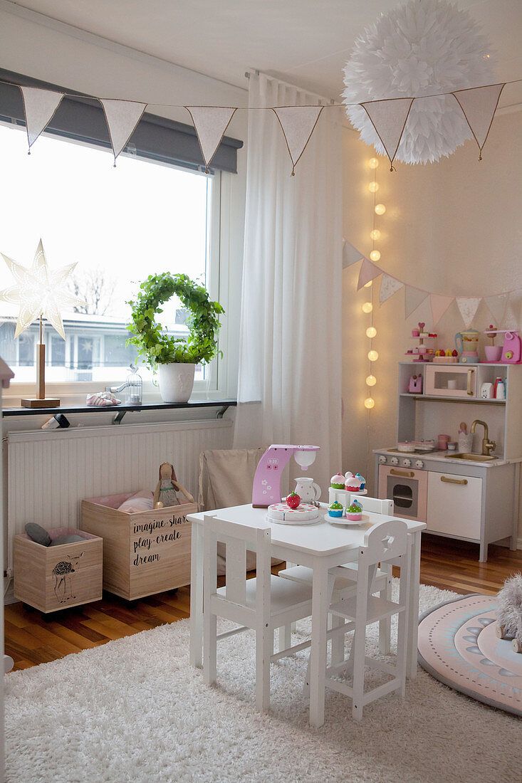 Kindertisch und Spielküche im gemütlichen Kinderzimmer mit Wimpelketten