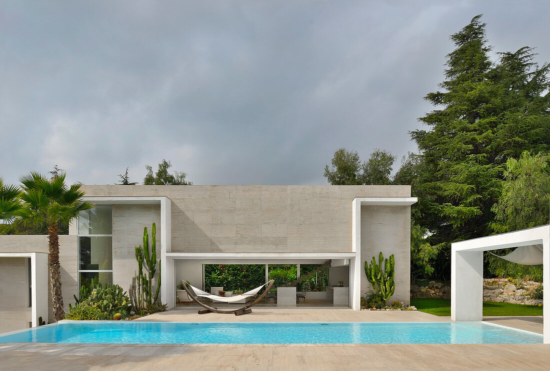 Modernes Architektenhaus mit Pool bei bewölktem Himmel