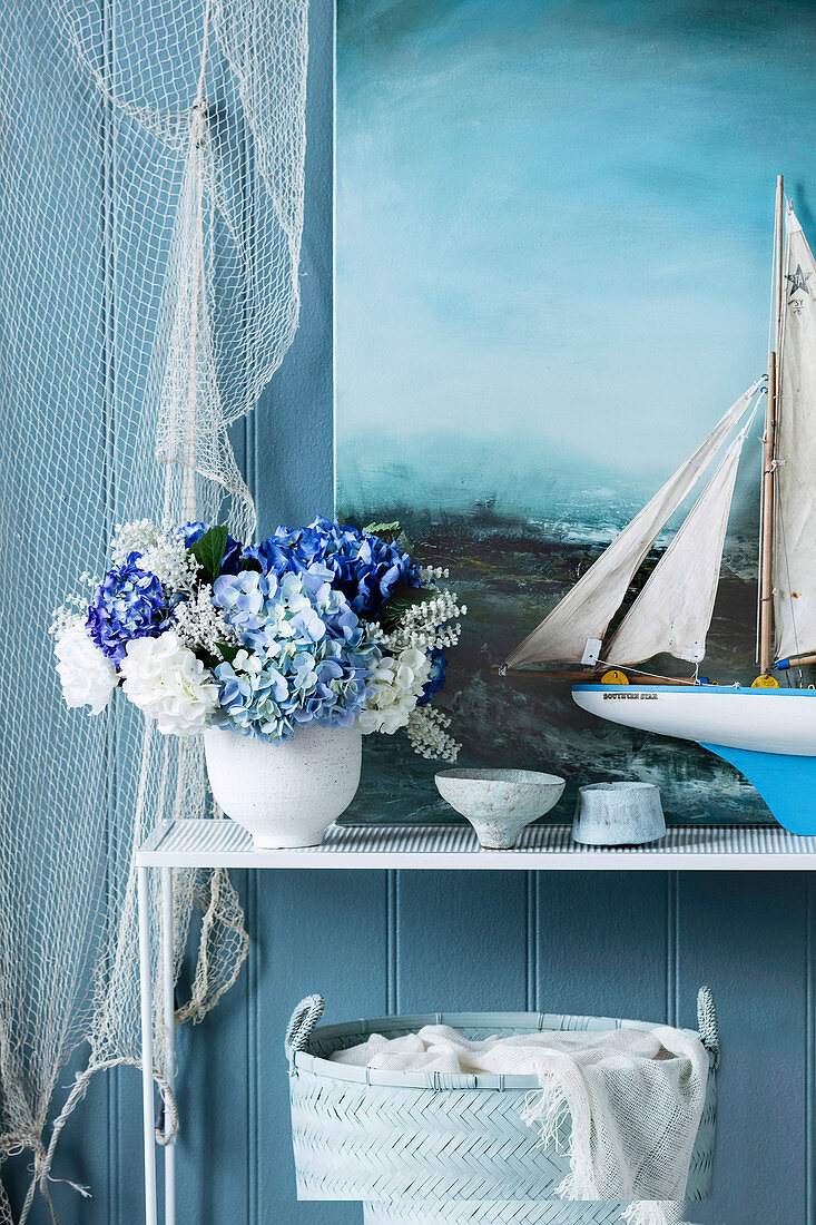 Hortensienstrauß, Segelschiffsmodell und Gemälde mit Meermotiv als maritime Dekoration