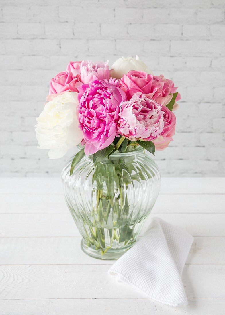Pink and white peonies in glass vase