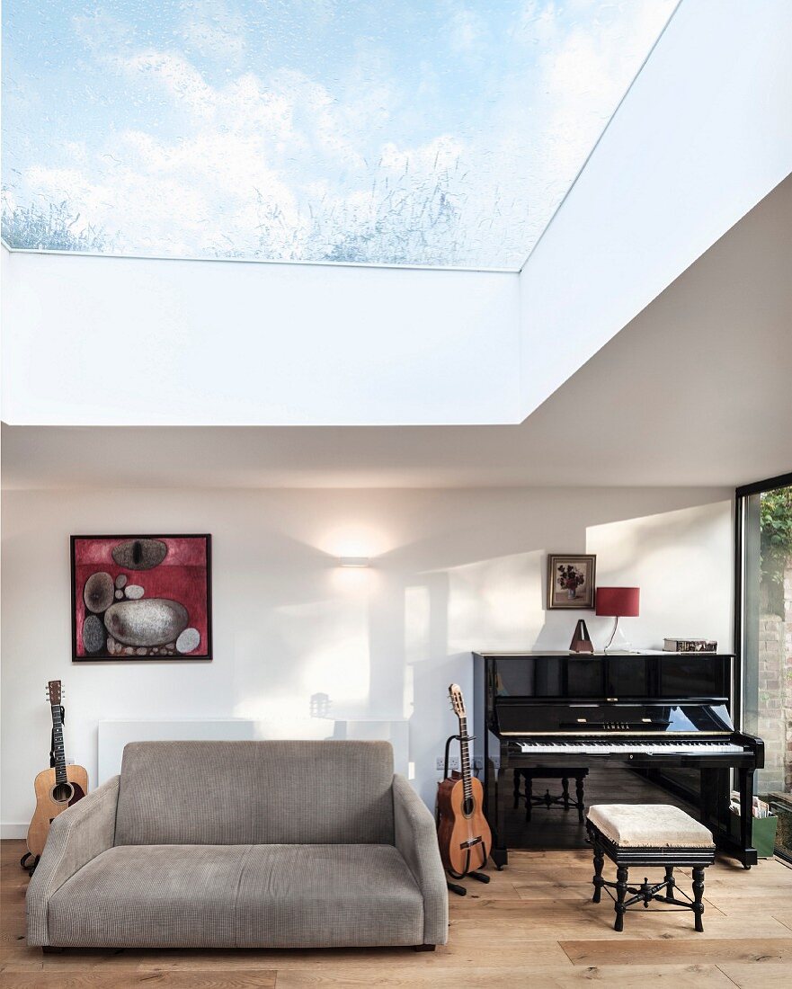 Music room with view of sky through glass roof