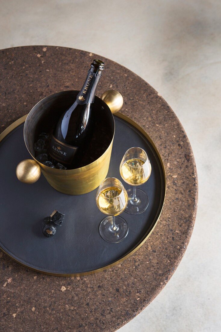 Brass wine cooler and tray on round cork table