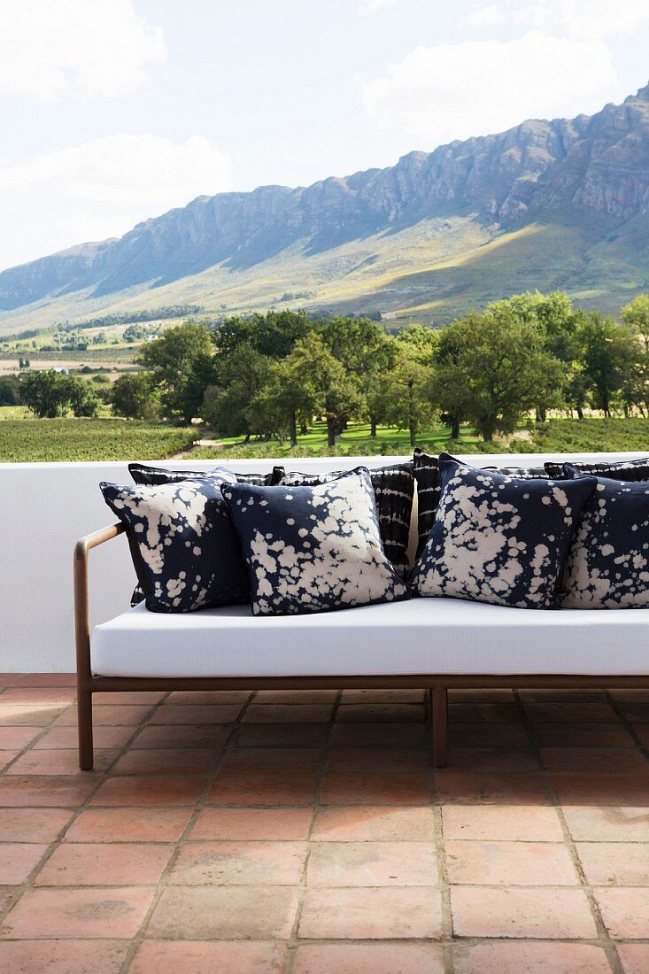 Batik scatter cushions on sofa on terrace with panoramic mountain view