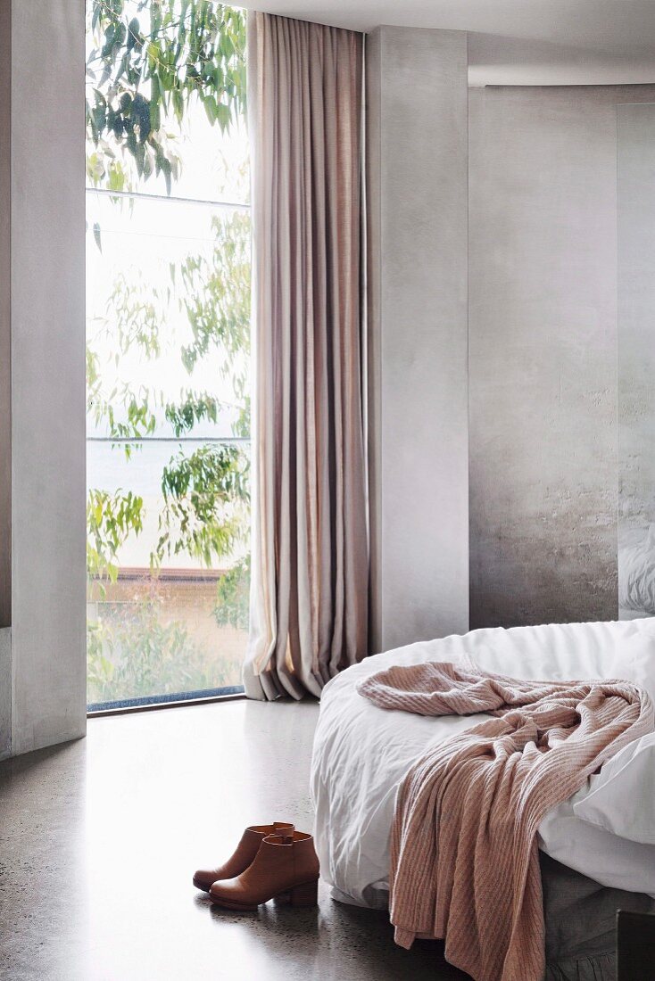 Schlafzimmer in Grautönen mit bodentiefem Fenster