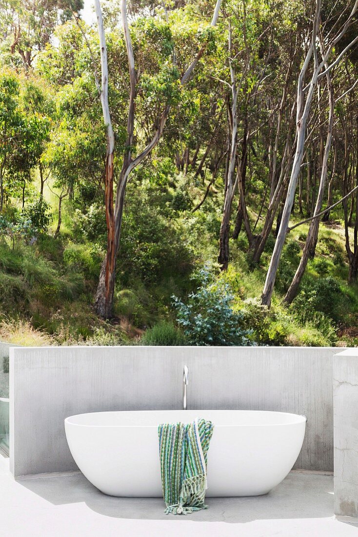 Moderne Badewanne im Freien mit Ausblick in den sommerlichen Wald