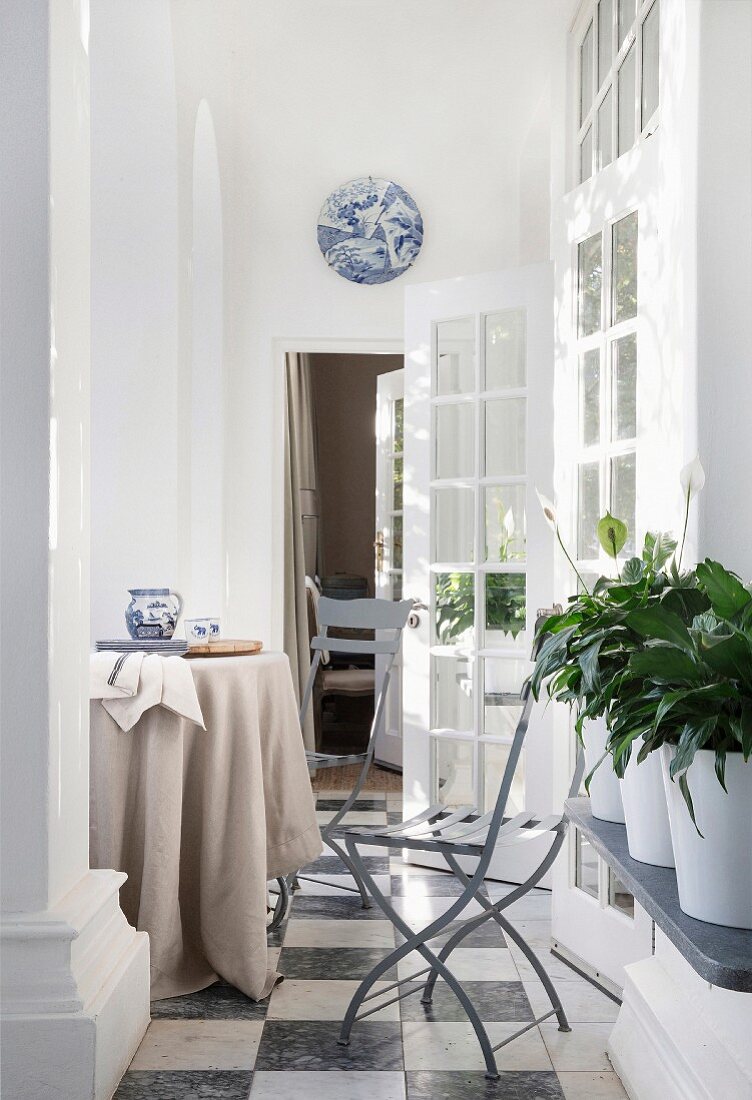 Round table and open French windows in bright loggia