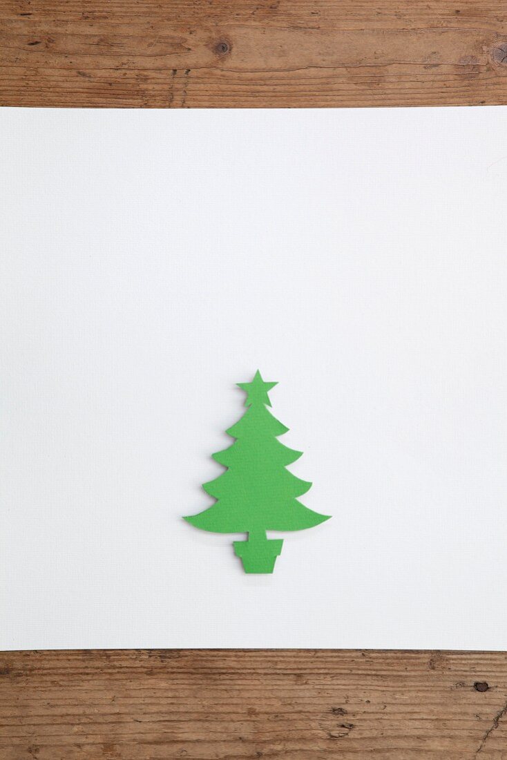 Weihnachtsbaum aus grünem Papier ausgeschnitten auf weißem Untergrund