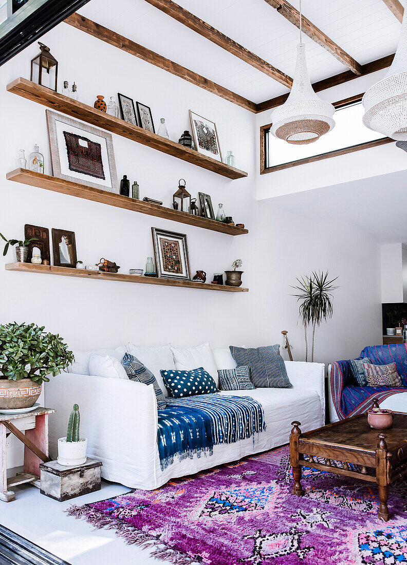 Regalbretter über dem Sofa im Wohnzimmer mit Boho-Flair