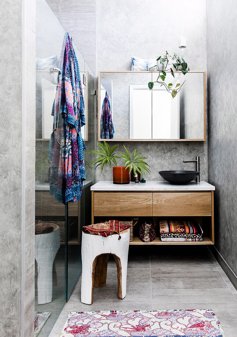 Narrow gray bathroom with glass wall for shower and boho flair