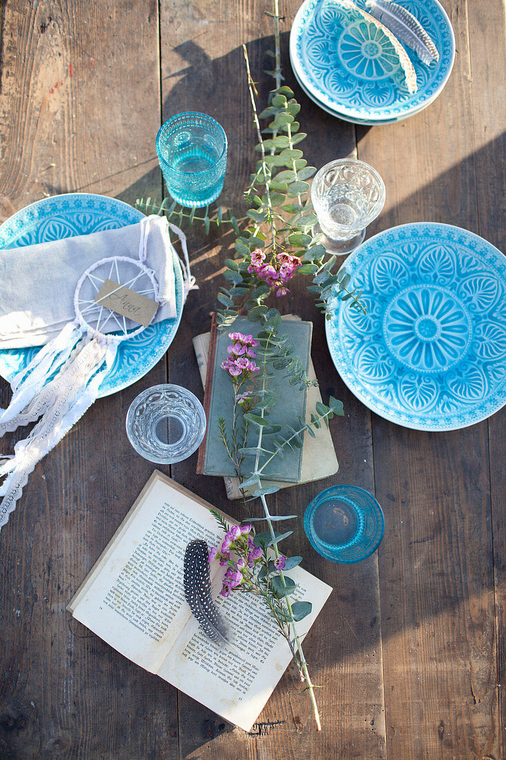 Mit Blauen Tellern gedeckter Holztisch im Sonnenlicht