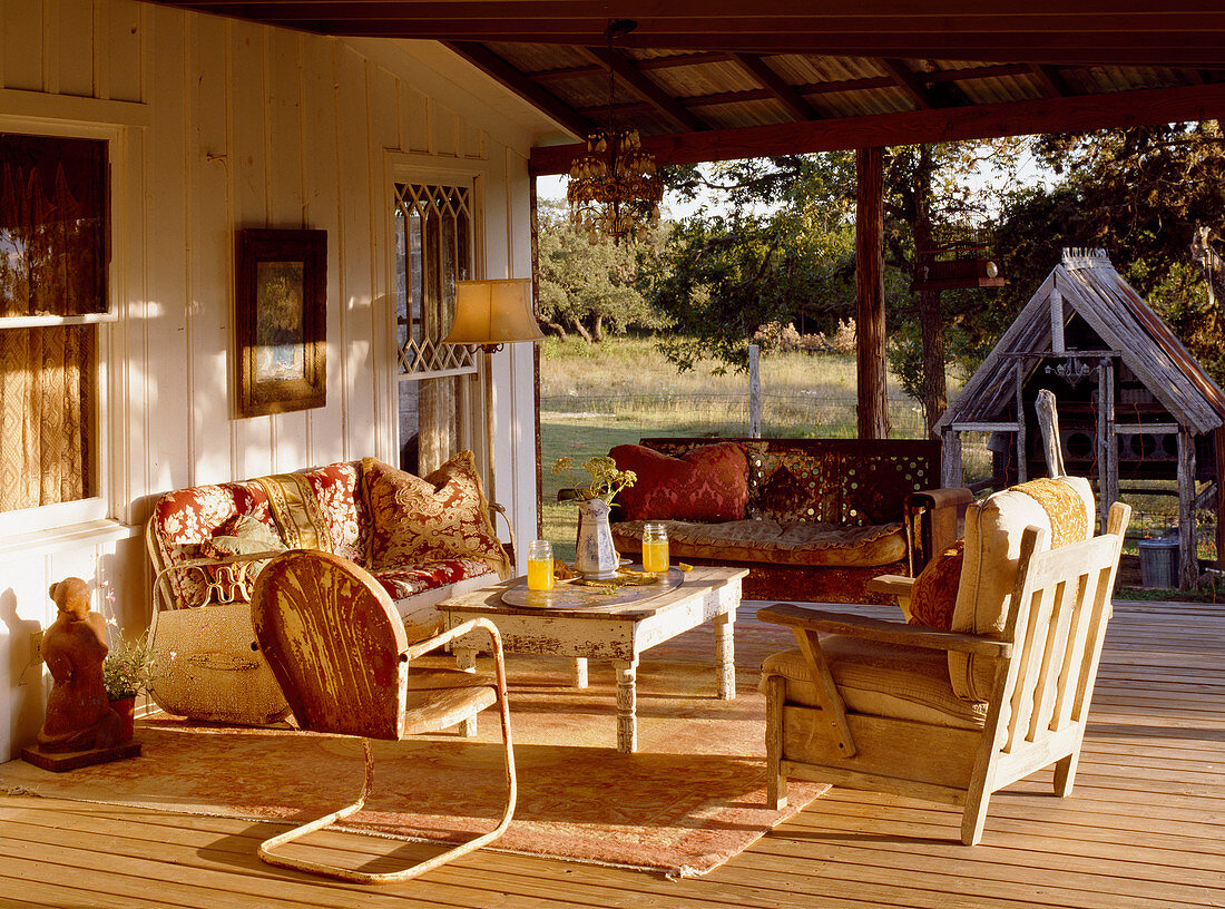 Sitzgruppe mit alten Möbeln auf der Veranda im gleißenden Sonnenlicht