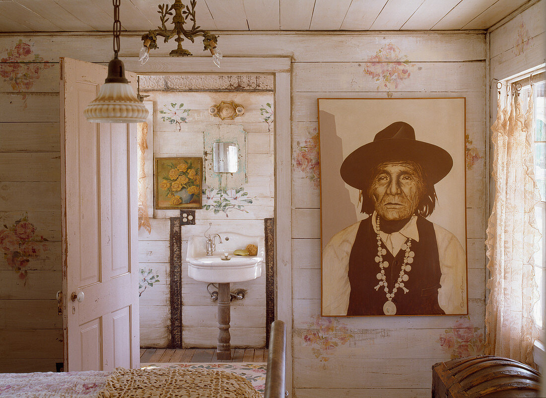 Portrait of Native American wearing hat in bedroom with view into bathroom