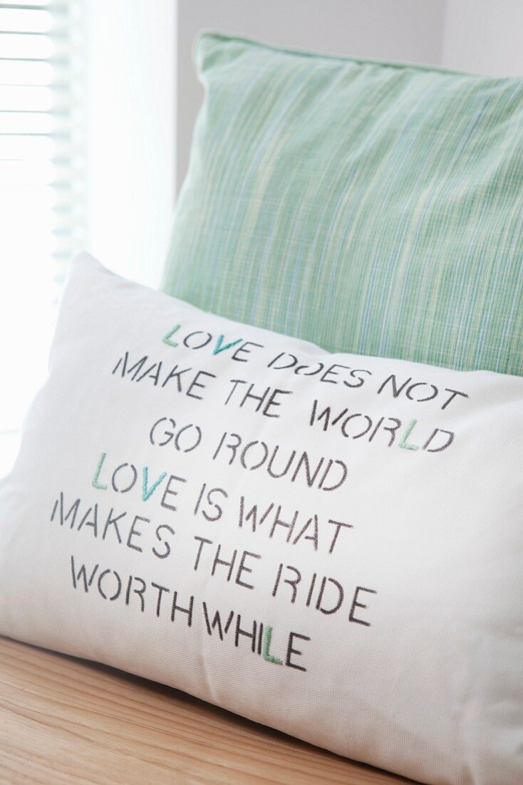 Hand-made cushion cover with printed and embroidered motto