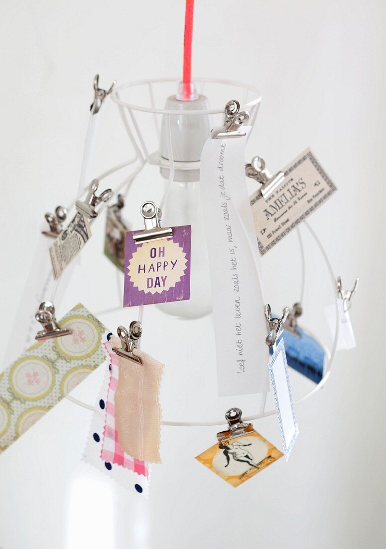 Various cards clipped to wire lampshade