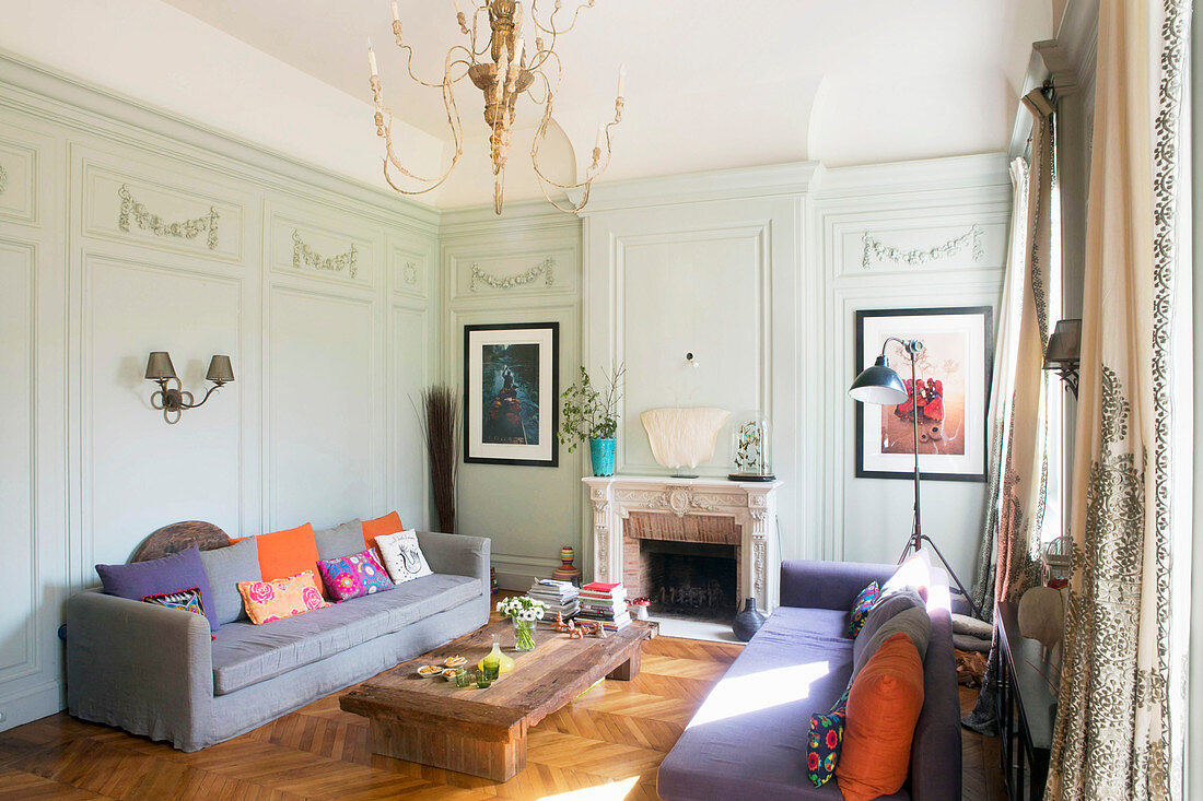 Colourful upholstery in living room with panelled walls and fireplace