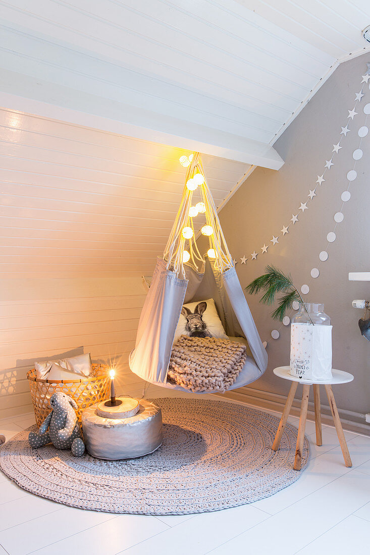 Hanging teepee chair in cosy corner of child's bedroom in shade s of grey and white