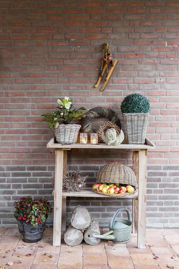 Potting table with wintry decorations against brick wall