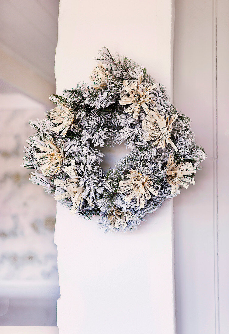 Christmas wreath with artificial snow and tassels made of sheet music