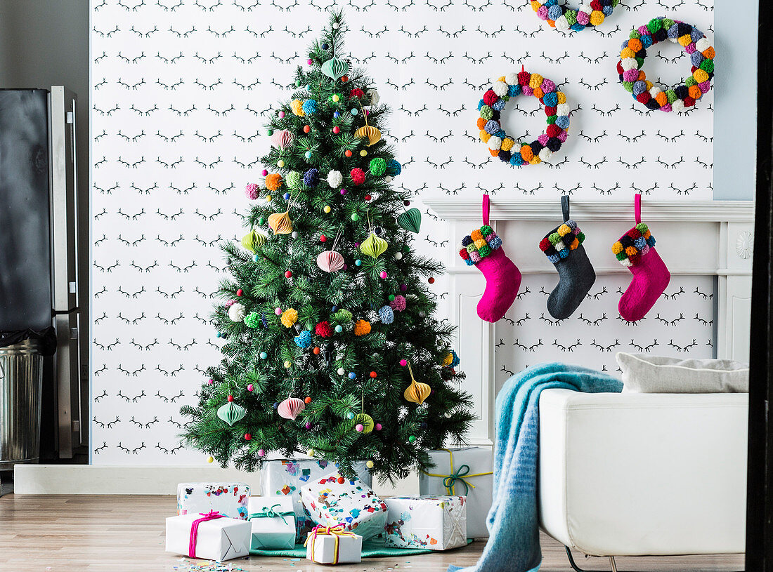Bunt geschmückter Weihnachtsbaum mit Pompoms und Geschenken