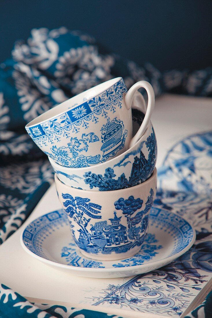 Stack of blue and white patterned china cups on saucer