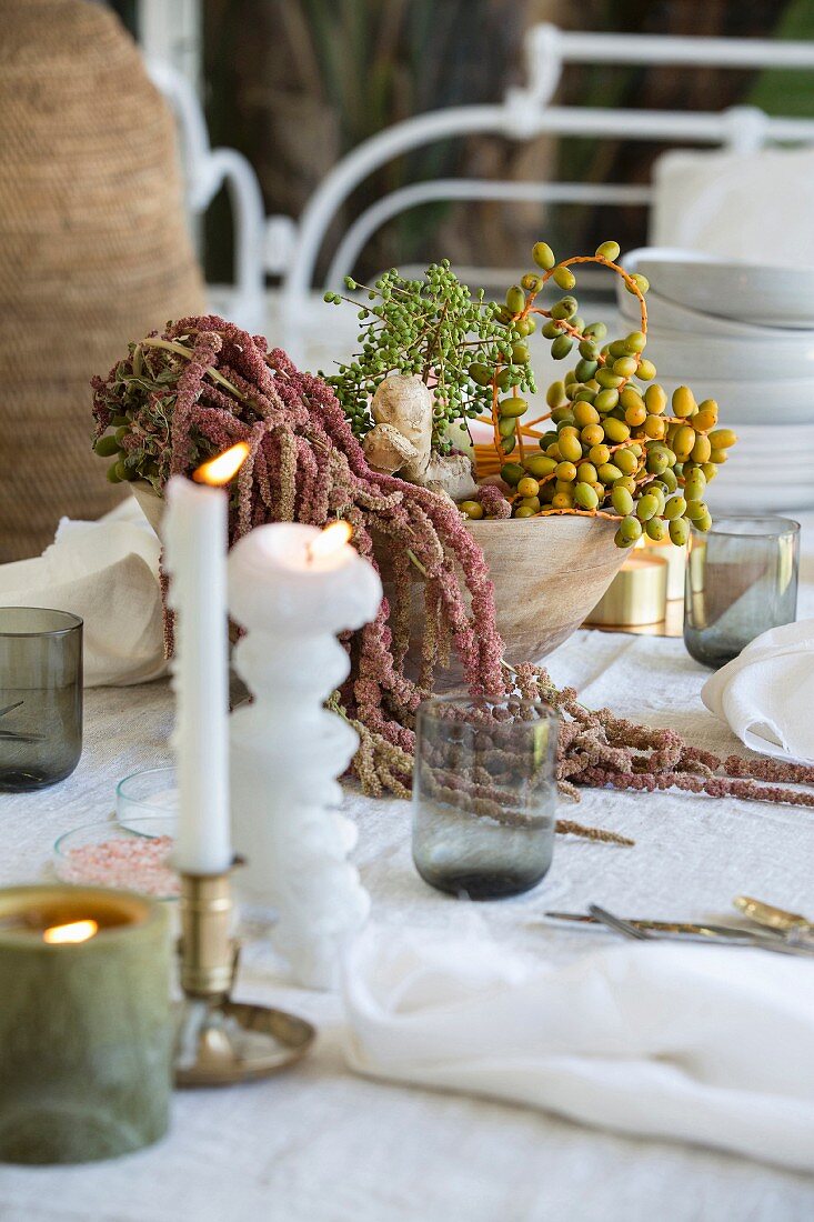 Gedeckter Tisch mit Pflanzendeko und Kerzen