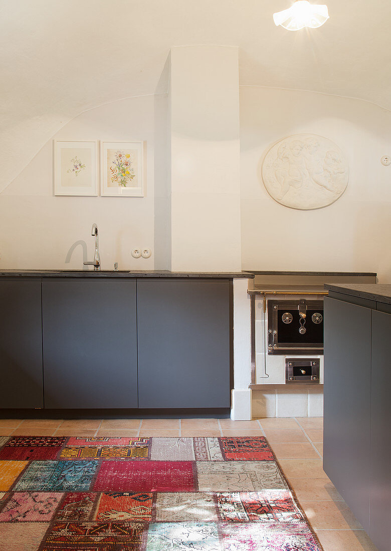 Grey cupboards in minimalist kitchen with vaulted ceiling