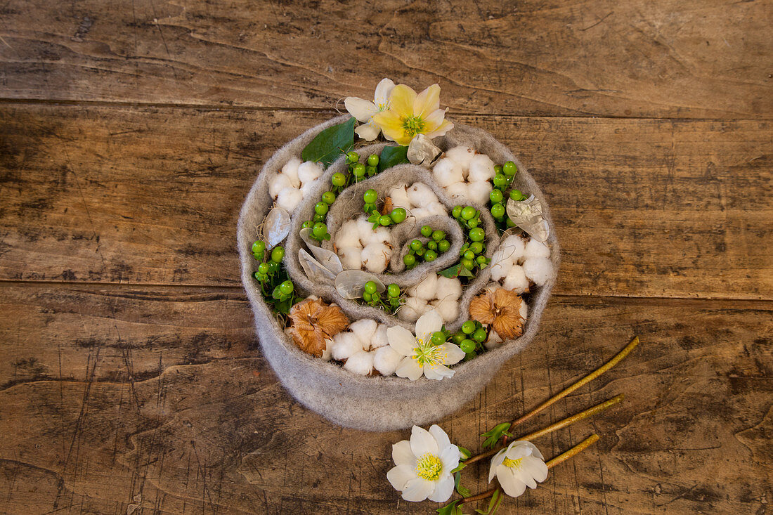 Spirale aus Filz mit Baumwolle, Johanniskraut und Christrosen