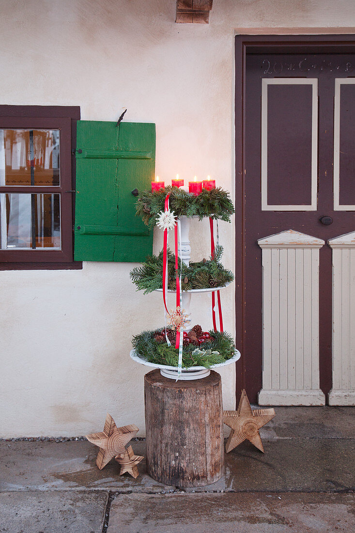 Three Advent wreaths on etagere outside front door of farmhouse