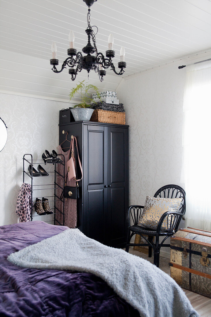 Schwarzer Kleiderschrank und Kronleuchter im Schlafzimmer im Vintage-Stil