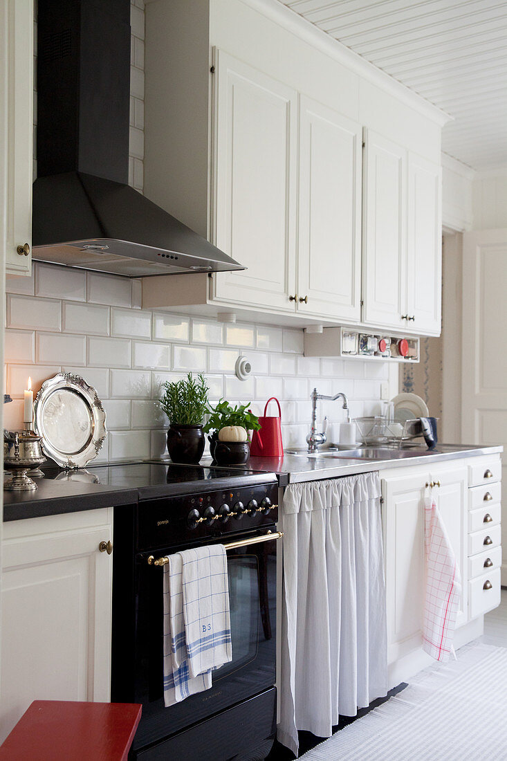 Scandinavian country-house kitchen with white cabinets and classic cooker