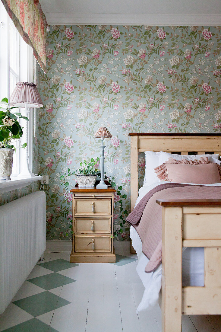 Painted wooden floor and floral wallpaper in romantic bedroom