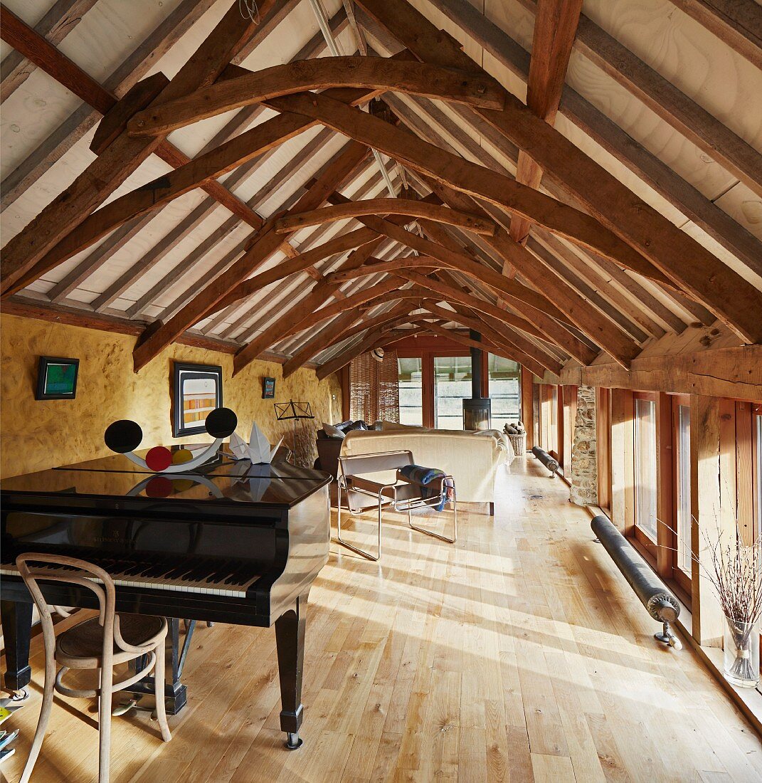 Helles Zimmer mit Klavierflügel in rustikalem Dachgeschoss mit restaurierter Fachwerkkonstuktion