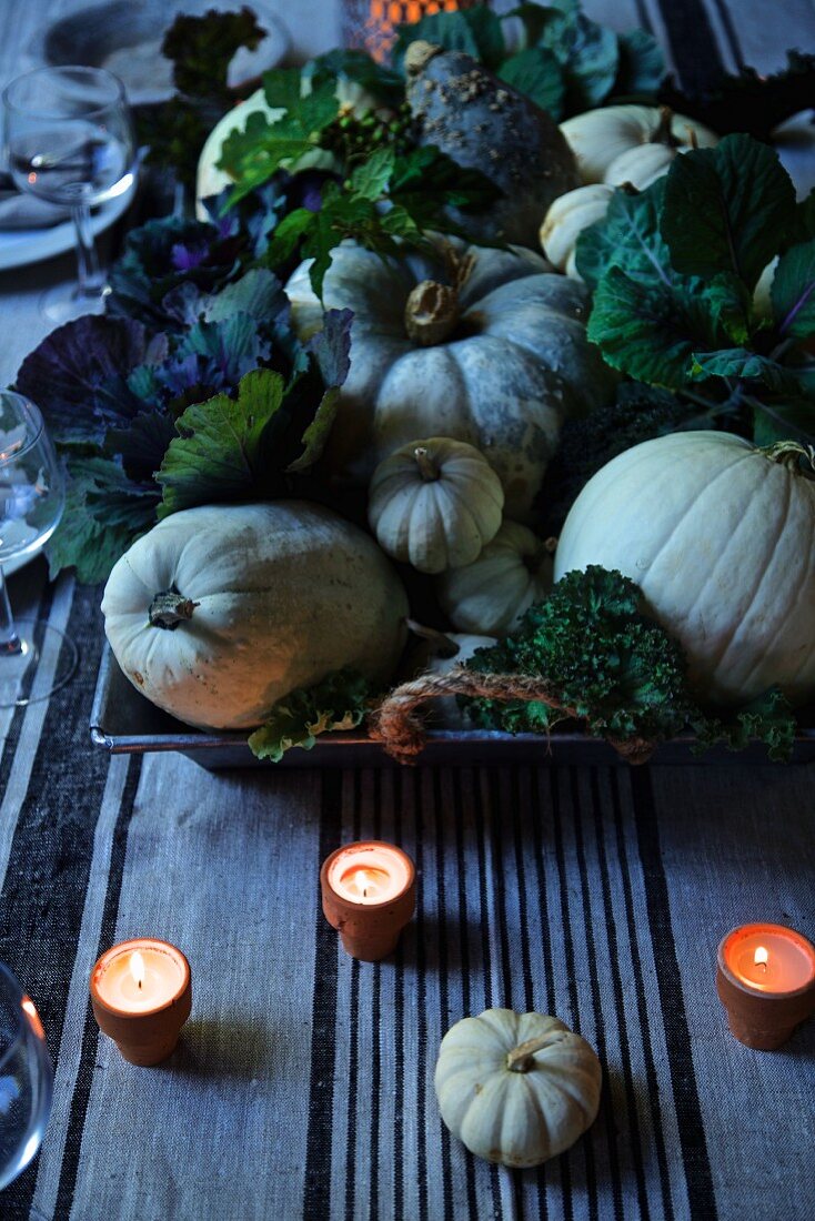 Herbstliche Tischdeko mit Kürbissen, Kohl und Teelichtern