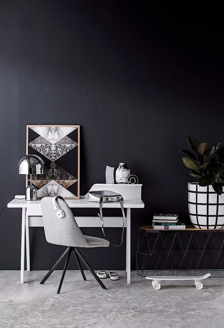 Gray chair and desk against black wall
