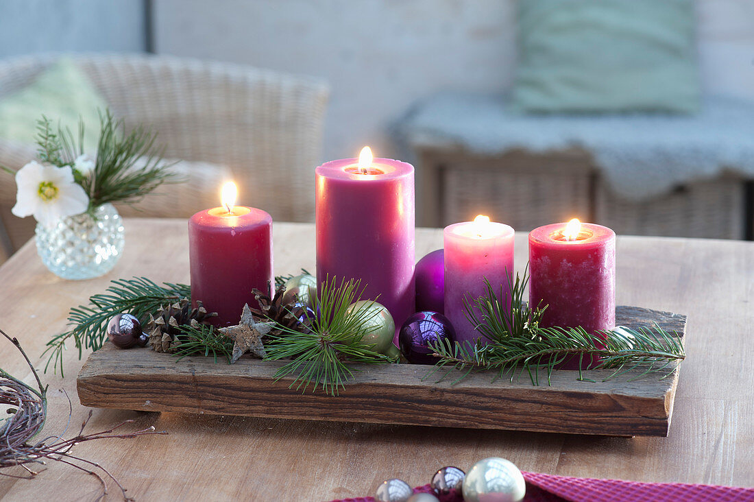 Fast Advent wreath made of 4 candles on wooden bowl, Pinus branches