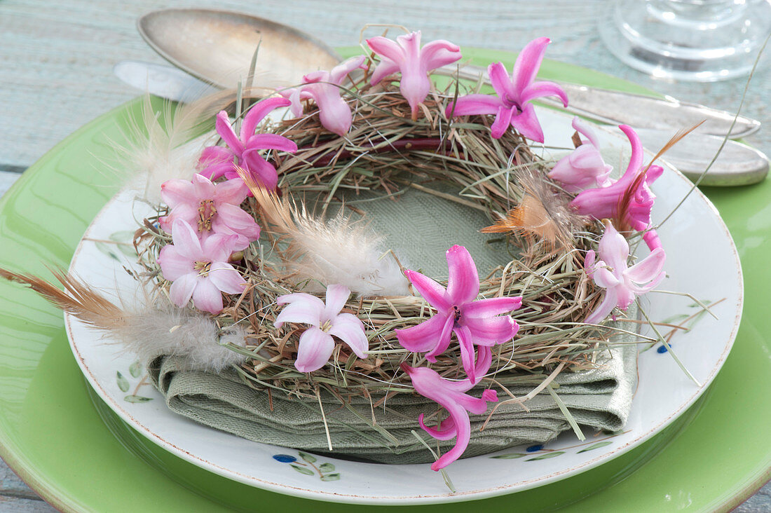 Small hay wreath with flowers of Hyacinthus and feathers