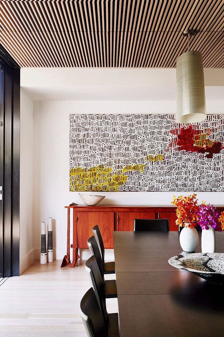 Large abstract painting above the red sideboard in the dining room