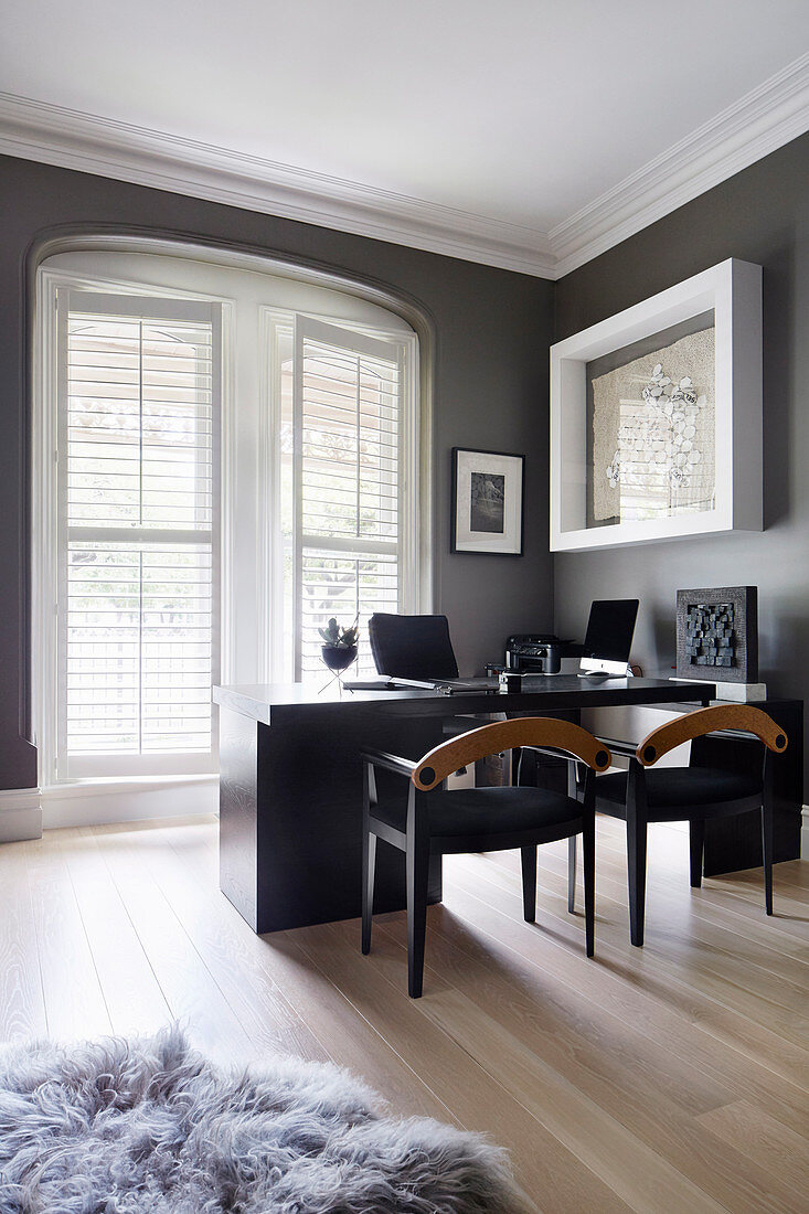 Two chairs in front of the desk in the masculine study