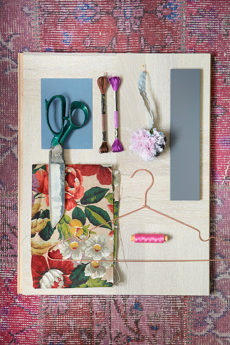 Mood board of floral fabric and wooden sewing utensils