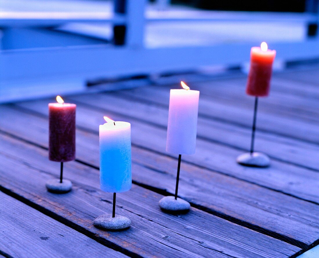 Lit pillar candles on wooden deck