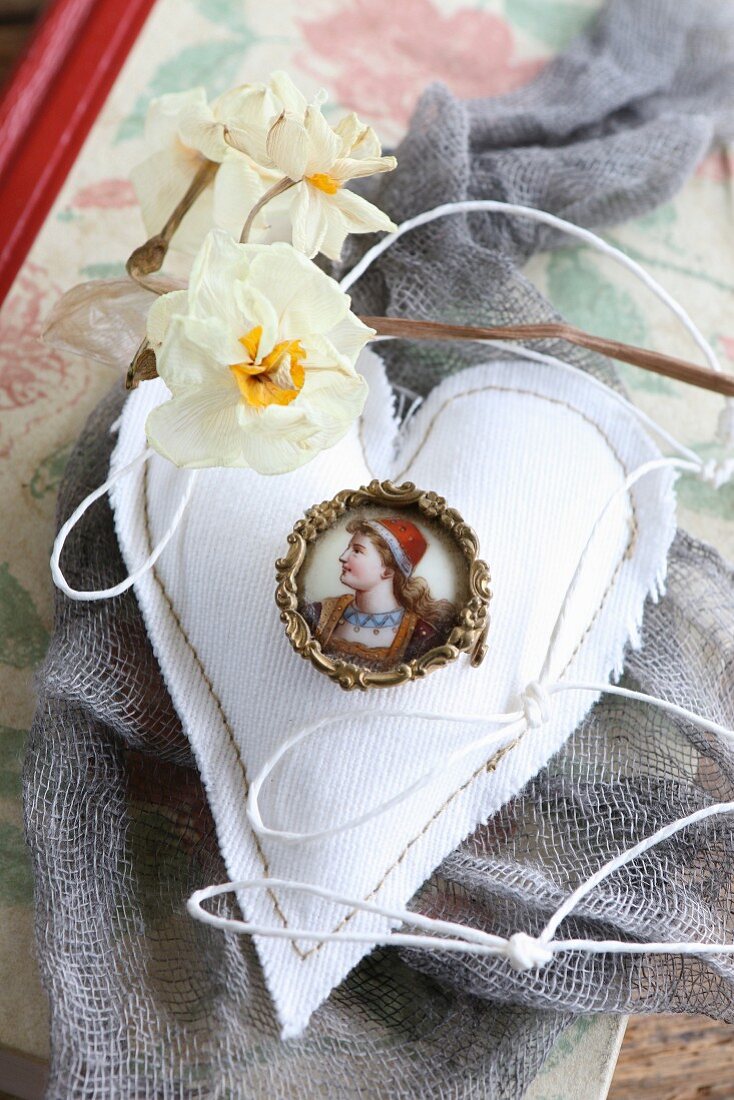 Old brooch on hand-sewn fabric heart