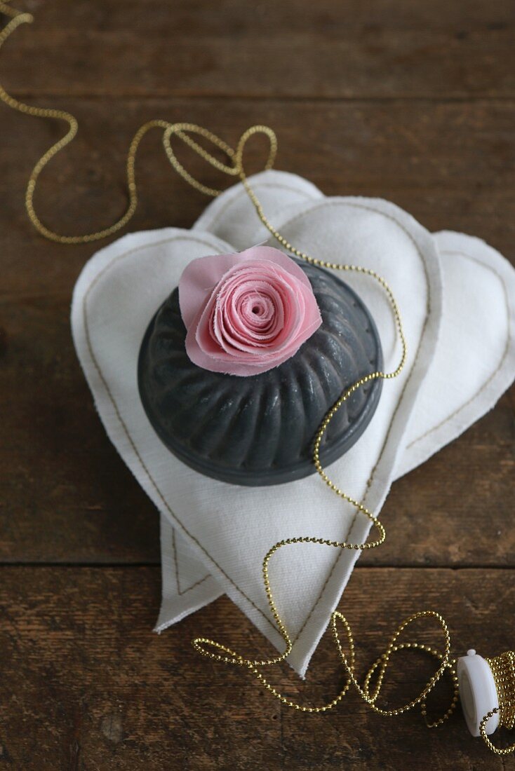Silk flower and bundt tin on two fabric hearts