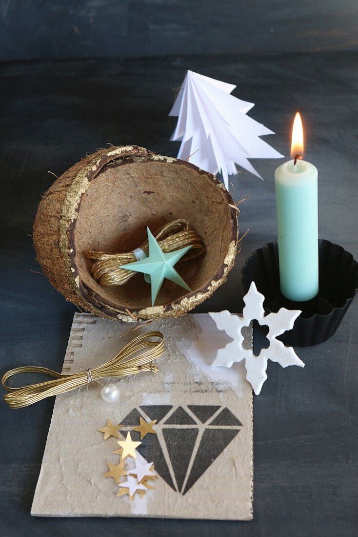 Weihnachtliches Stillleben mit brennender Kerze und Kokosnuß