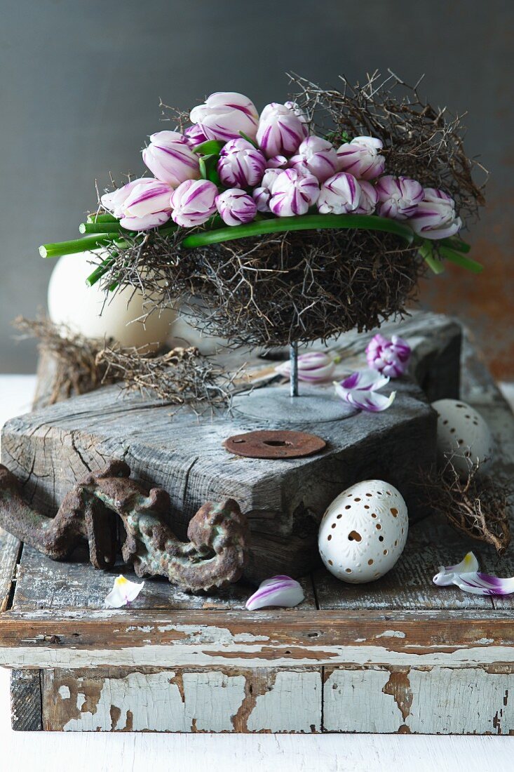 Pink and white tulips in nest of twigs on stand
