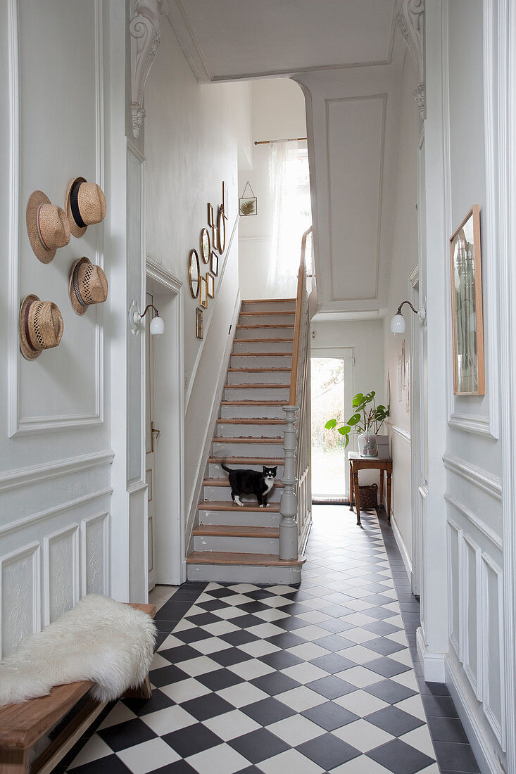 Staircase in hallway with chequered floor and panelled walls