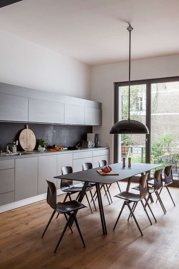 Modern dining set in large, grey fitted kitchen with balcony