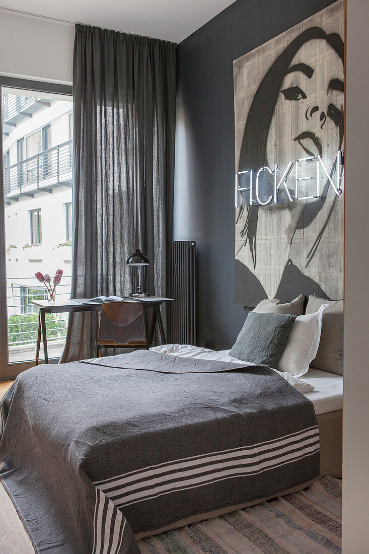 Schlafzimmer in Grautönen mit einem Bild und Leuchtschrift