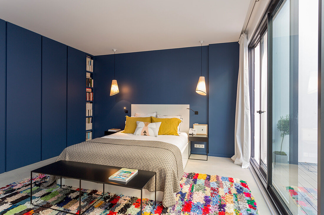Blaue Wände und Einbauschränke im Schlafzimmer mit Fensterfront