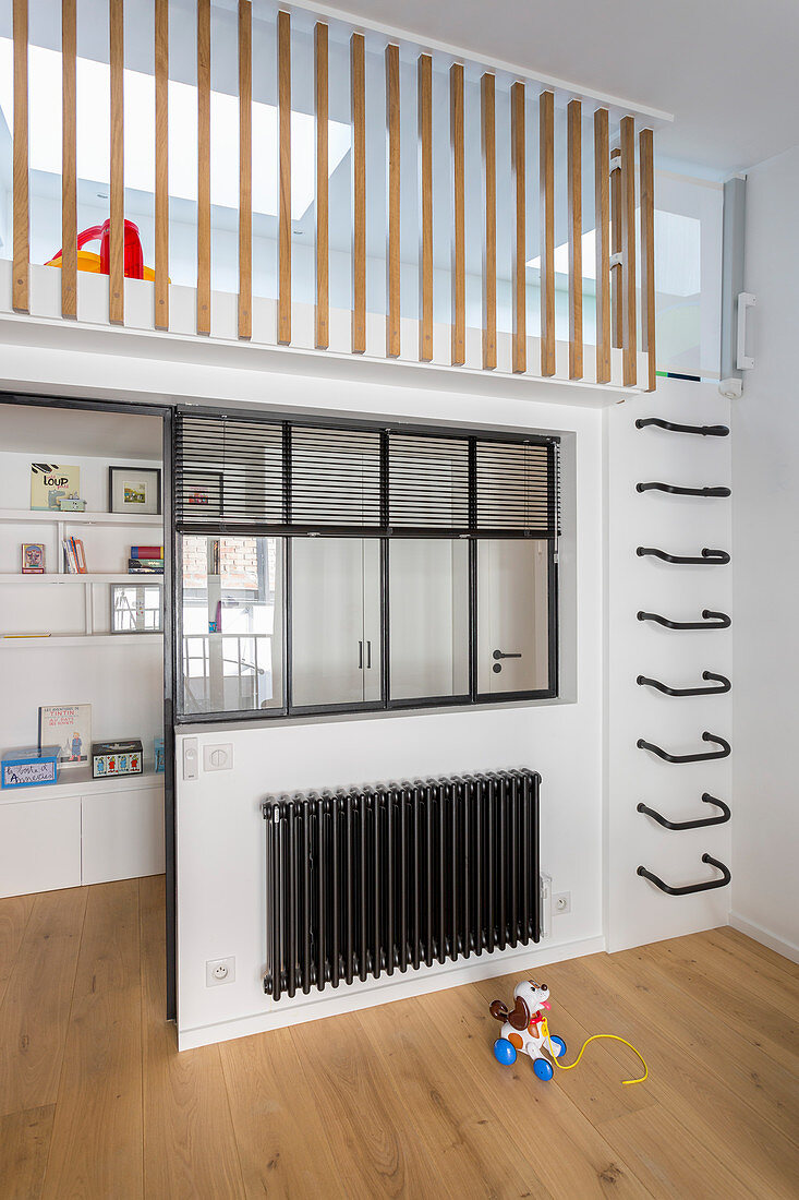 Wall-mounted ladder rungs leading to mezzanine in child's bedroom