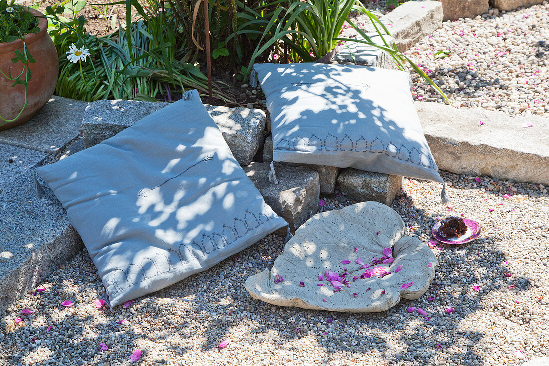 Cushions and leaf-shaped dish on gravel terrace